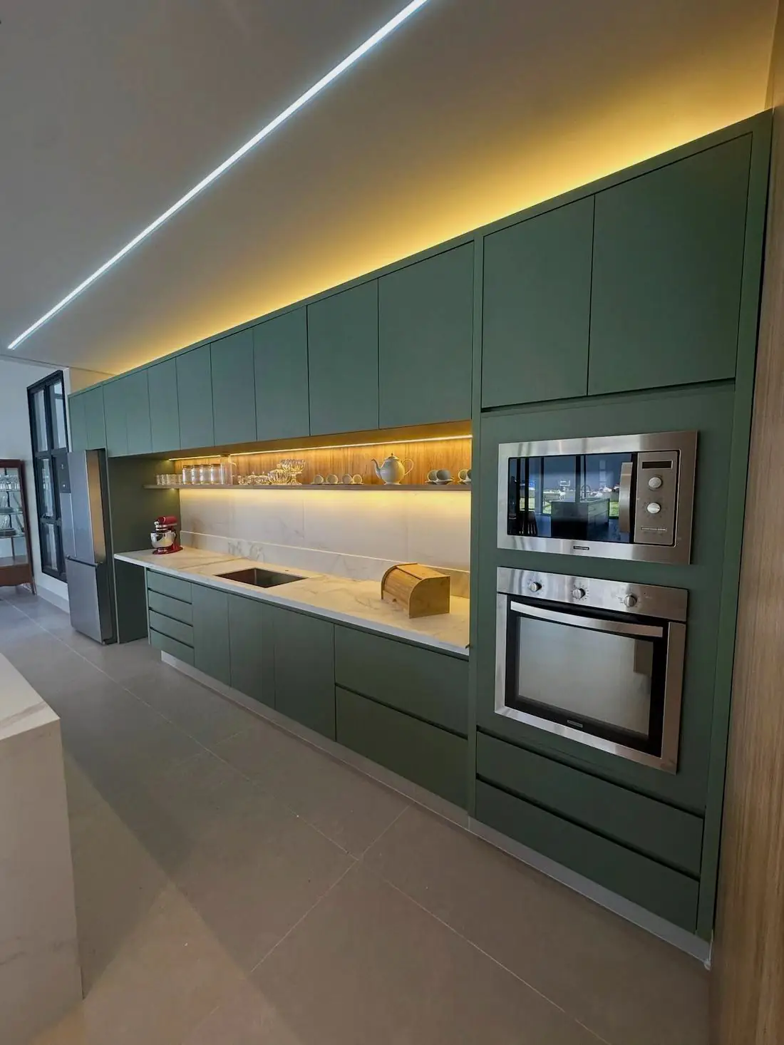 Cozinha planejada verde com torre de forno e micro-ondas embutidos